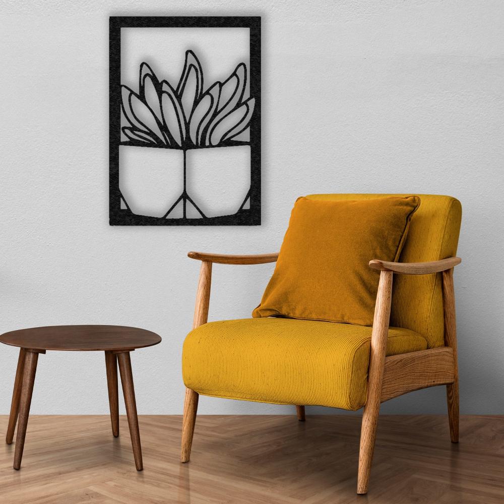 A warm corner with a mustard armchair and a wooden table, highlighted by a black "Vase with Succulent" metal wall art on a white wall, creating a cozy and inviting space.