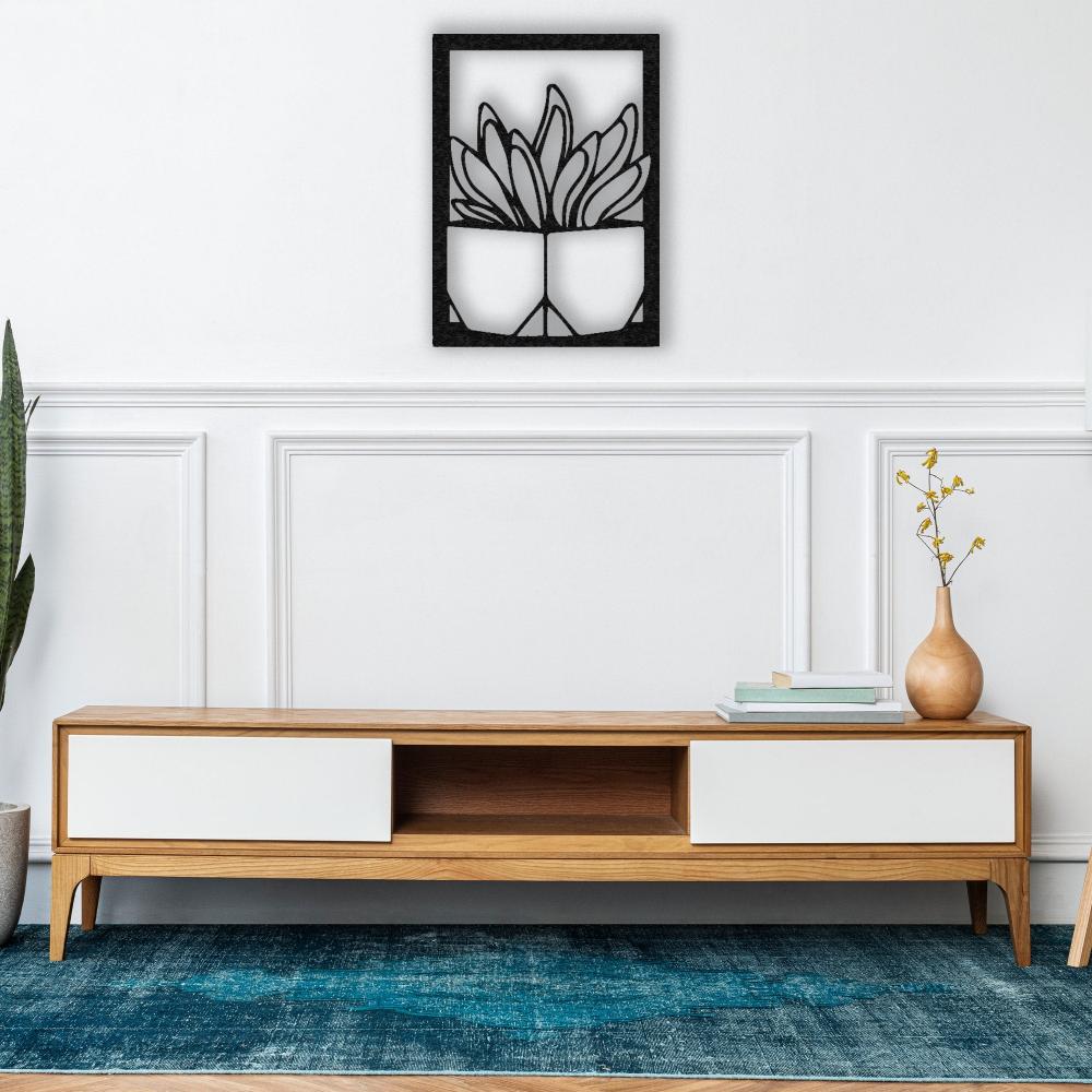 A modern and minimalist living room featuring a sleek wooden console, a vibrant blue rug, and a black "Vase with Succulent" metal wall art mounted on a white paneled wall.