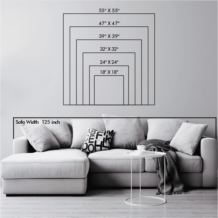 Wall car logo art size chart displaying dimensions ranging from 18"x18" to 55"x55", shown above a modern 125-inch wide sofa in a minimalist living room. The setup includes neutral cushions and a small circular side table for scale reference.