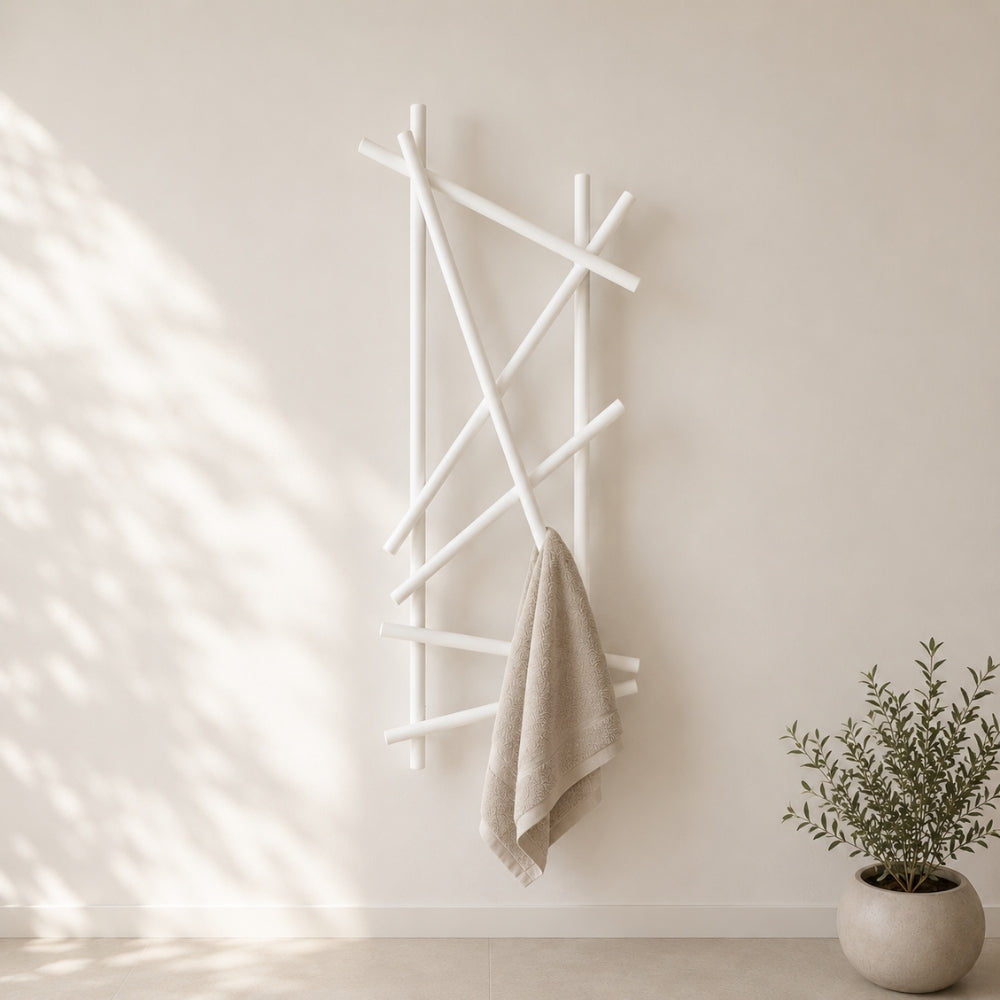 White wall mounted branch towel rack holding a beige towel on a light bathroom wall.