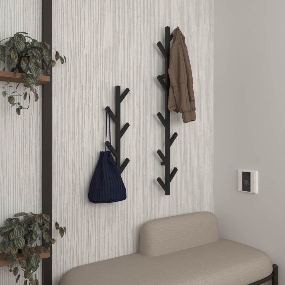 wall mounted tree shaped coat rack entryway organizerWall-mounted minimalist coat rack with a tree design, featuring two racks holding a brown coat and a blue bag against a plain white background.