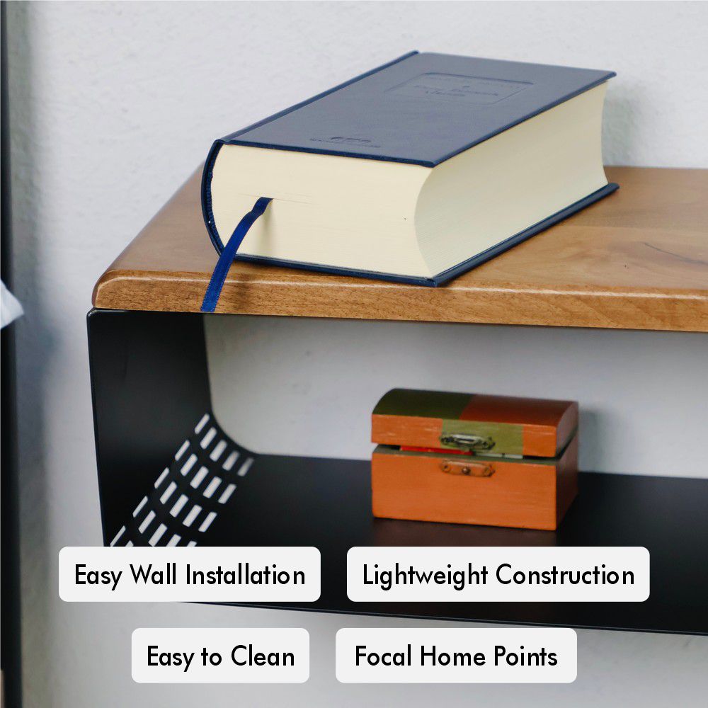 Close-up of a wall-mounted wooden and black metal bedside table. The natural wood top holds a blue book, while the black metal base includes a small decorative wooden box, highlighting its stylish and practical design.