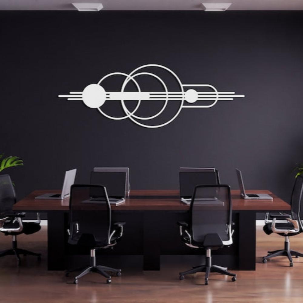 White mid-century modern wall art featuring overlapping circular and linear designs mounted on a black wall, displayed in a modern office setting with a dark wooden conference table and black office chairs.