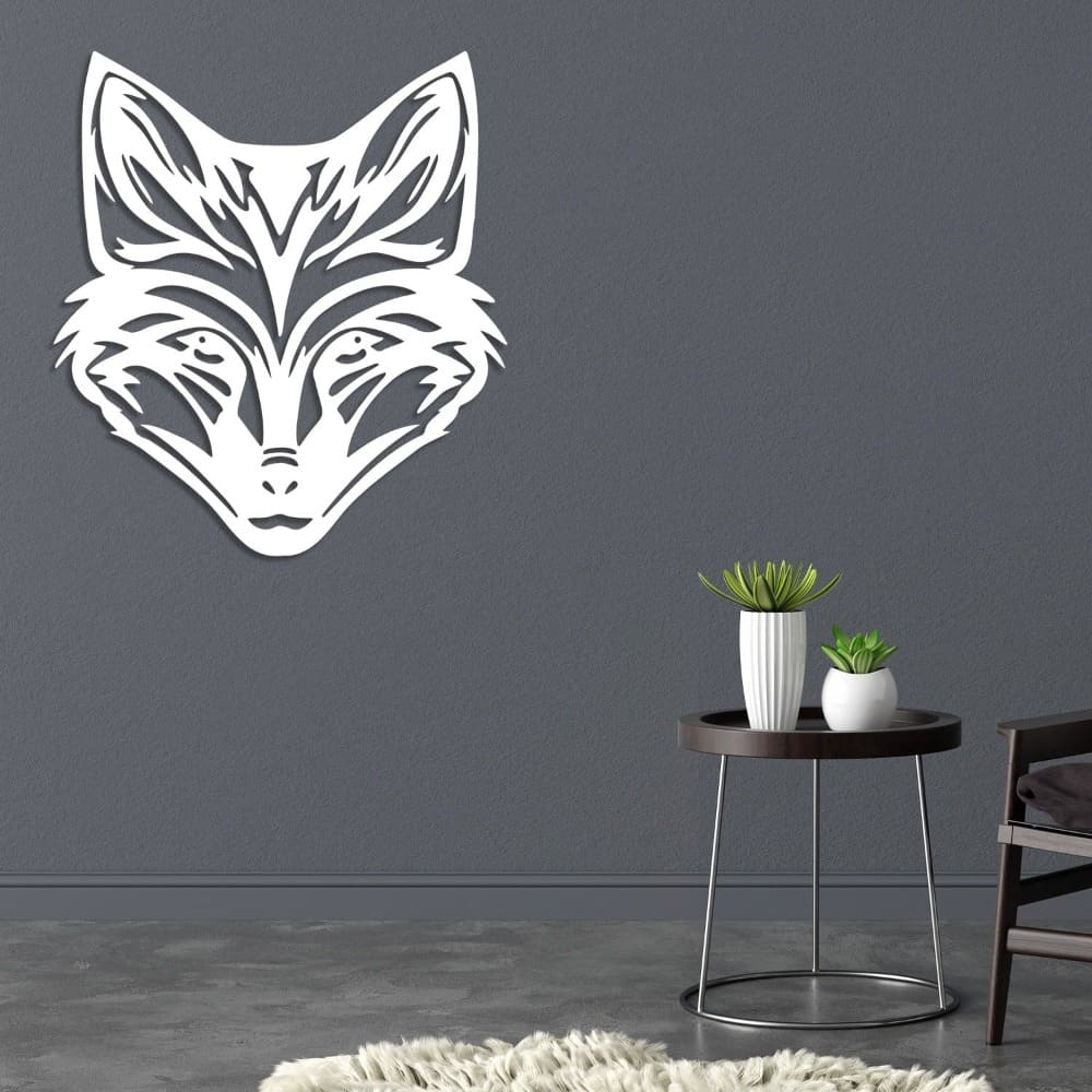 White metal wall art featuring a detailed fox head design, mounted on a dark gray wall. Below, a modern round black table holds two decorative potted plants, with a cozy shag rug and part of a sleek chair completing the minimalist decor.
