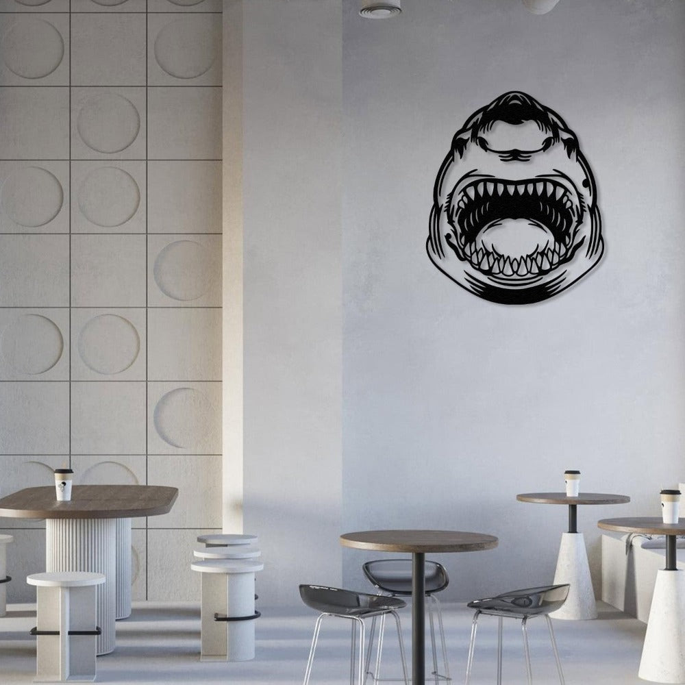 Black metal shark wall art hanging in a minimalist cafe with modern furniture and light decor