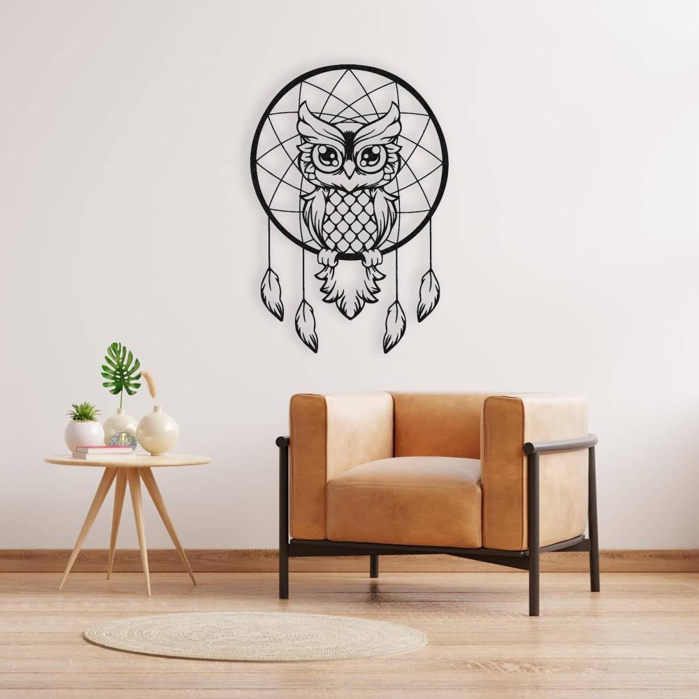 Wise owl dreamcatcher black metal wall art installed above a tan leather chair with a side table, adding a touch of elegance to the space.