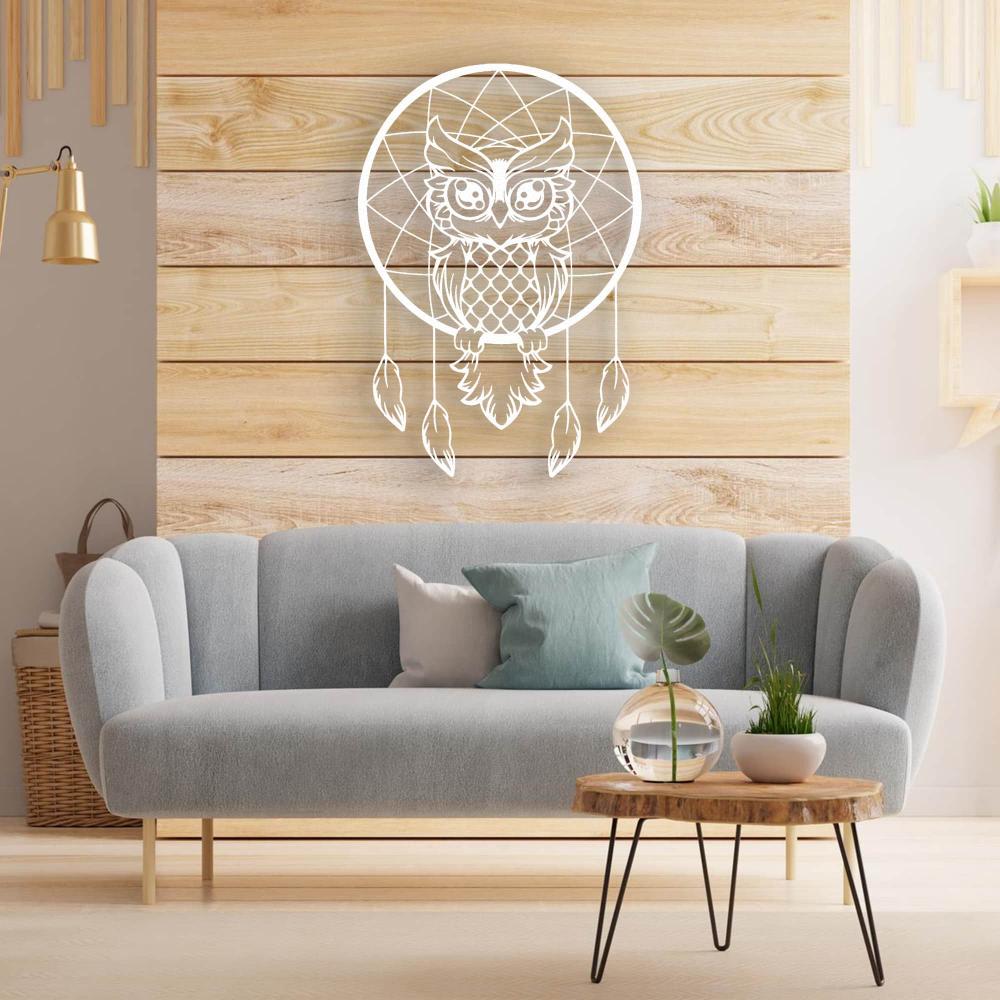 White metal wall art of a wise owl dreamcatcher displayed on a wooden accent wall above a light blue sofa, styled with modern decor.
