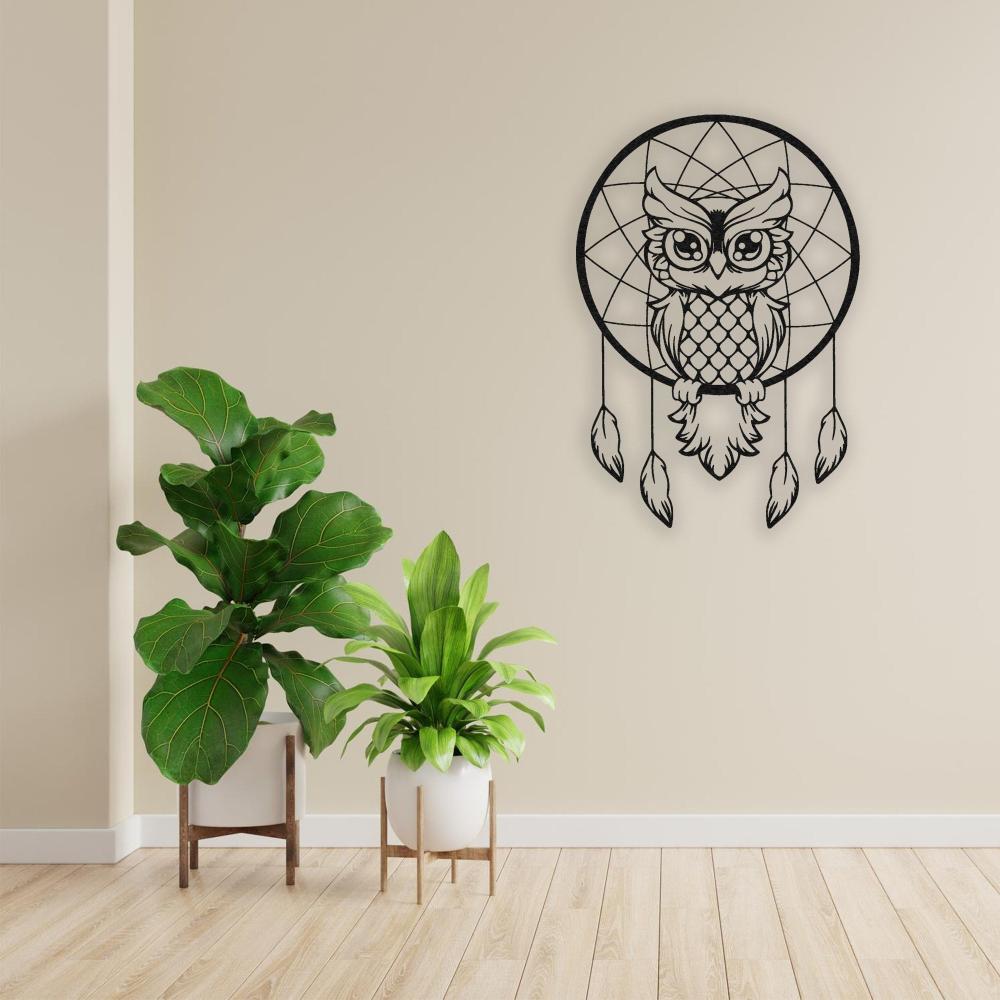 Black metal wall art of a wise owl dreamcatcher displayed on a beige wall, styled with lush green plants in modern planters.