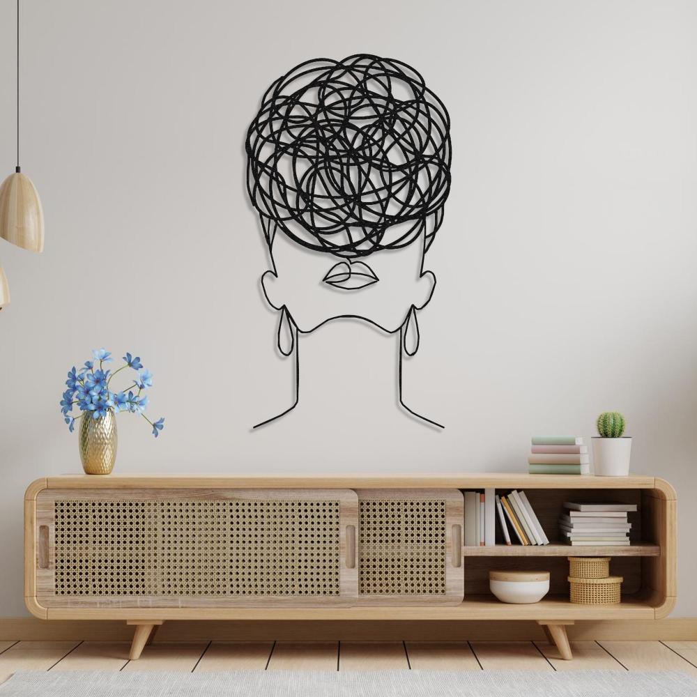 Artistic wall decor of a woman's silhouette with circular pattern hair, mounted above a modern wooden sideboard with minimal decor.