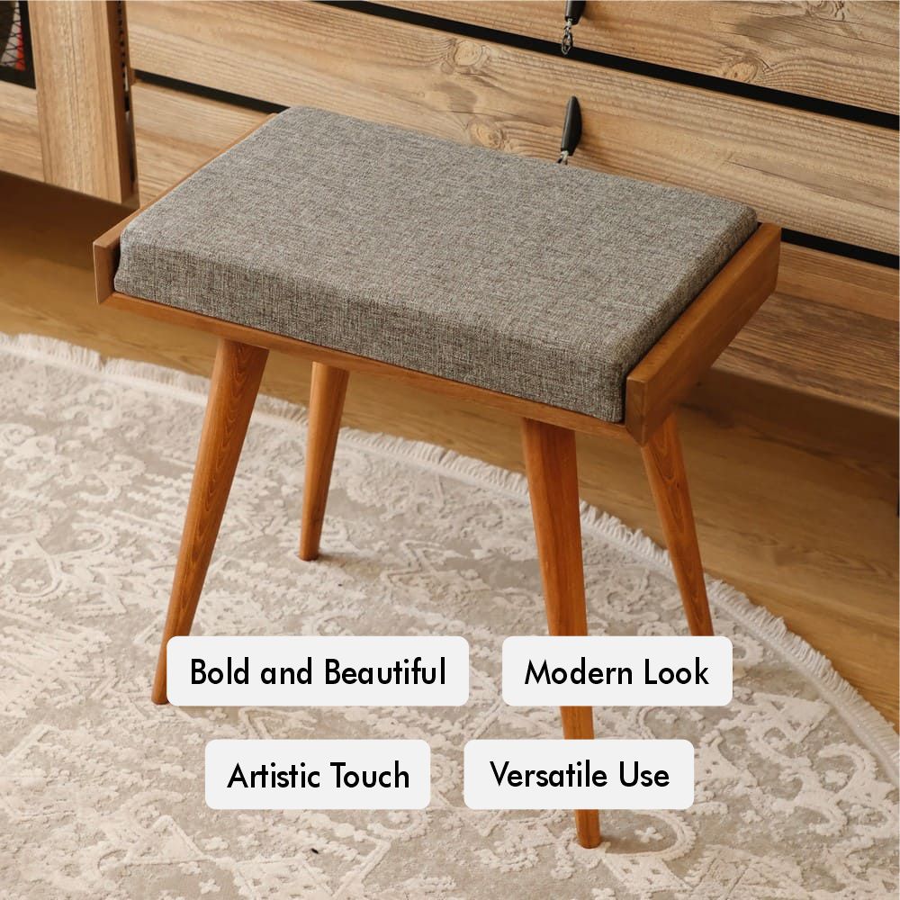 Wooden bench with grey cushioned seat placed on a patterned rug, in front of a wooden chest of drawers.