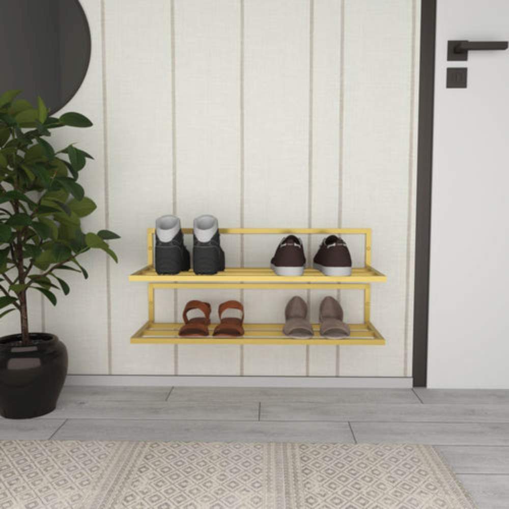 A yellow wall-mounted shoe rack with two tiers, displaying boots, sneakers, and heels, situated in an entryway with a potted plant, a circular mirror, and a beige paneled wall