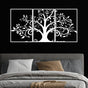 Three-piece white metal wall art featuring an intricate tree design with swirling branches and leaves, mounted on a black wall above a modern bed. The bed is styled with gray bedding, houndstooth-patterned pillows, and beige accent pillows, creating a bold and elegant bedroom look.