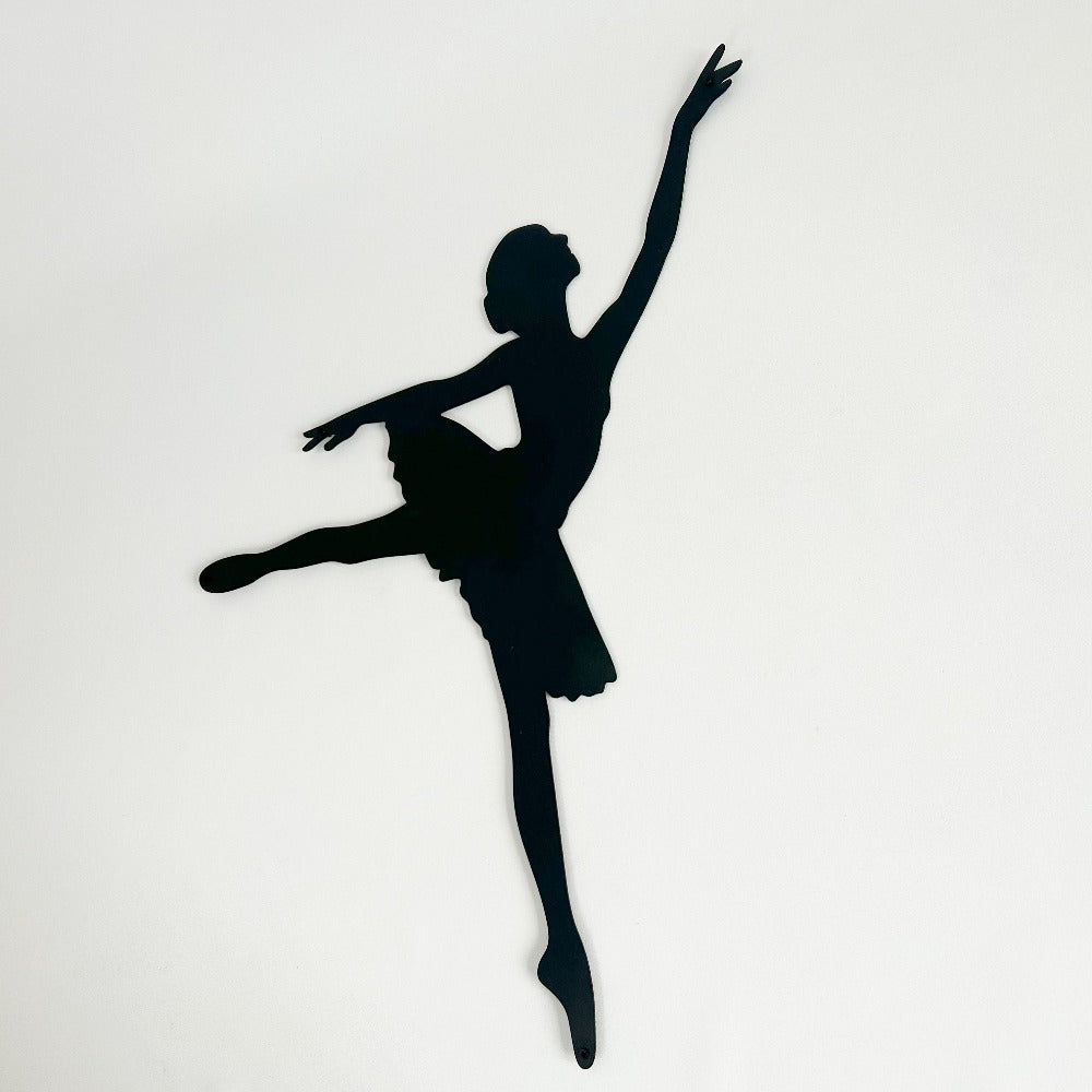 Black ballerina silhouette metal wall art shown against a clean background with the figure in a motion pose.