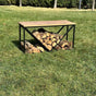 A black metal wood rack with a wooden top, showcasing stacked firewood underneath, placed indoors next to a fireplace