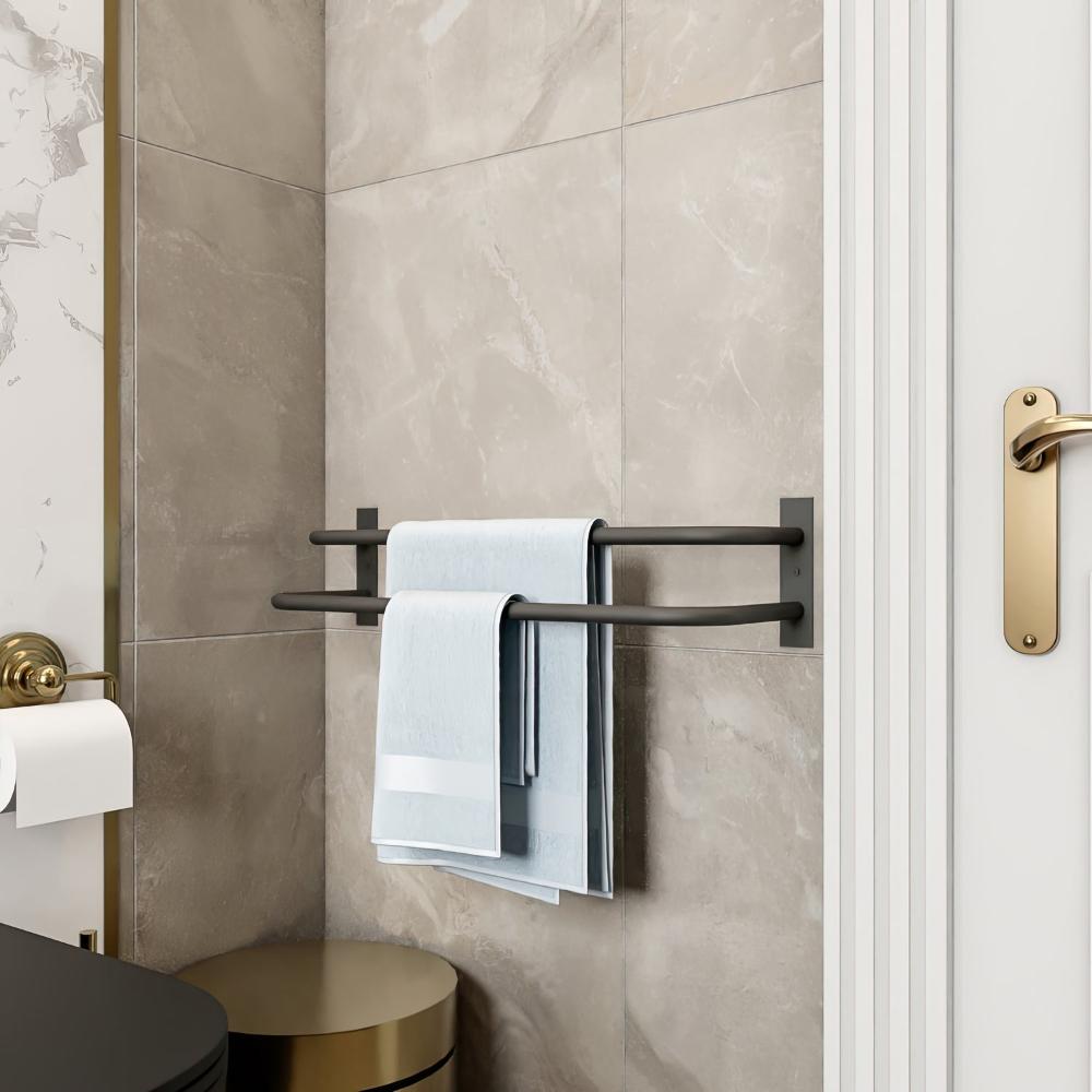 A clean and minimalistic bathroom setting featuring a black double-bar towel holder mounted on the wall, holding neatly folded blue towels. The neutral tones of the tiles and the golden door handle add an elegant touch to the overall design.
