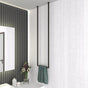 Ceiling-mounted towel rack in a modern bathroom with a white textured wall, holding a green towel for a minimalist aesthetic.
