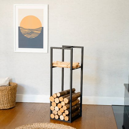 Wooden logs stacked on the Modern Metal Firewood Rack against a wall with a framed abstract art piece