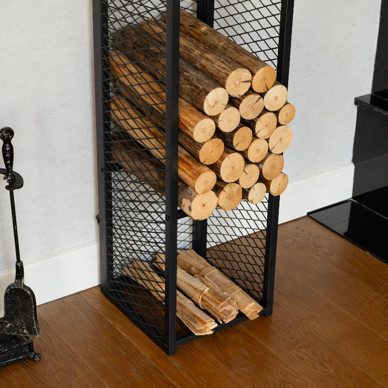 Black metal firewood rack with stacked logs against a white wall.