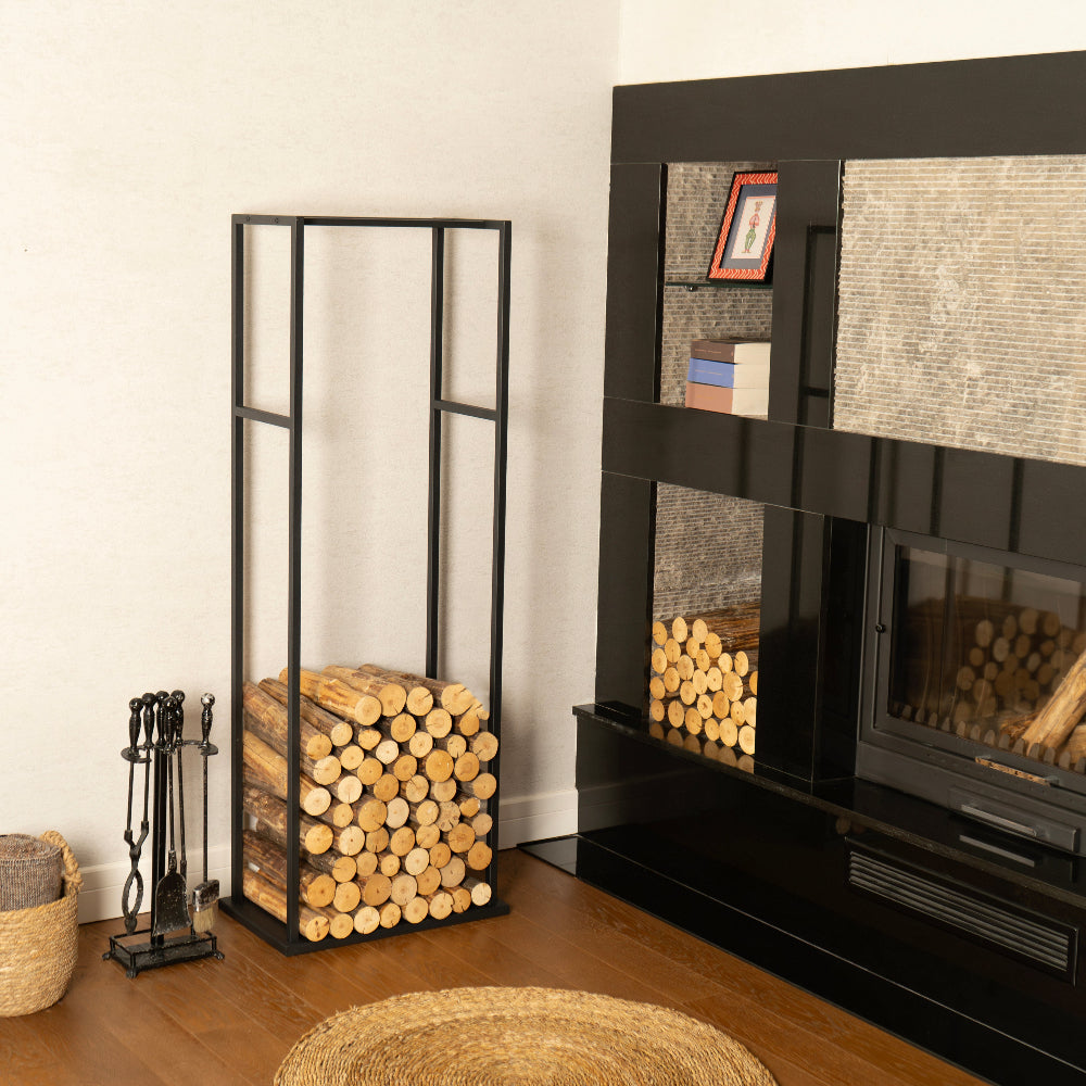 Black fireplace with stacked logs and decorative items in a room.
