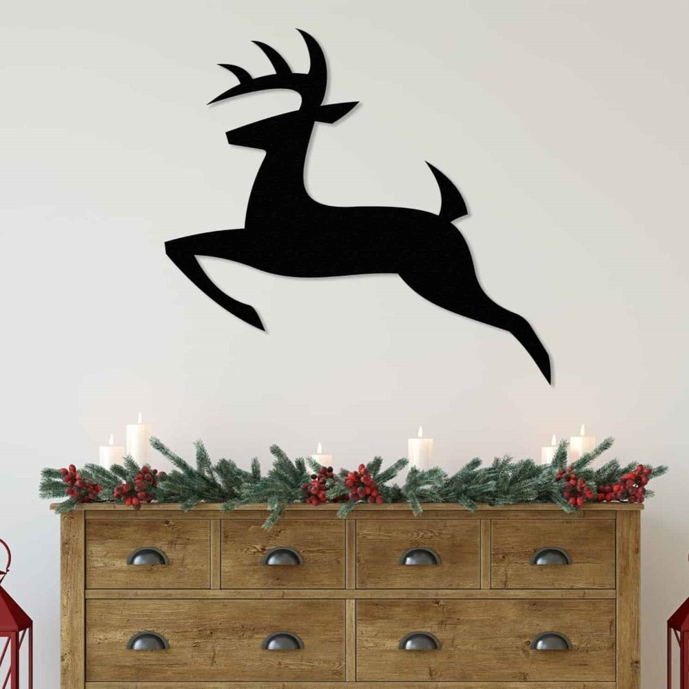 Black silhouette deer metal wall decor mounted on a light gray textured wall, with a rustic wooden bench and minimalist tree branch vase below, creating a modern and serene atmosphere.