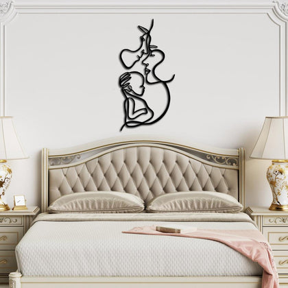 Decorative black metal family line art piece mounted above a luxurious classic bed with gold-accented furniture.