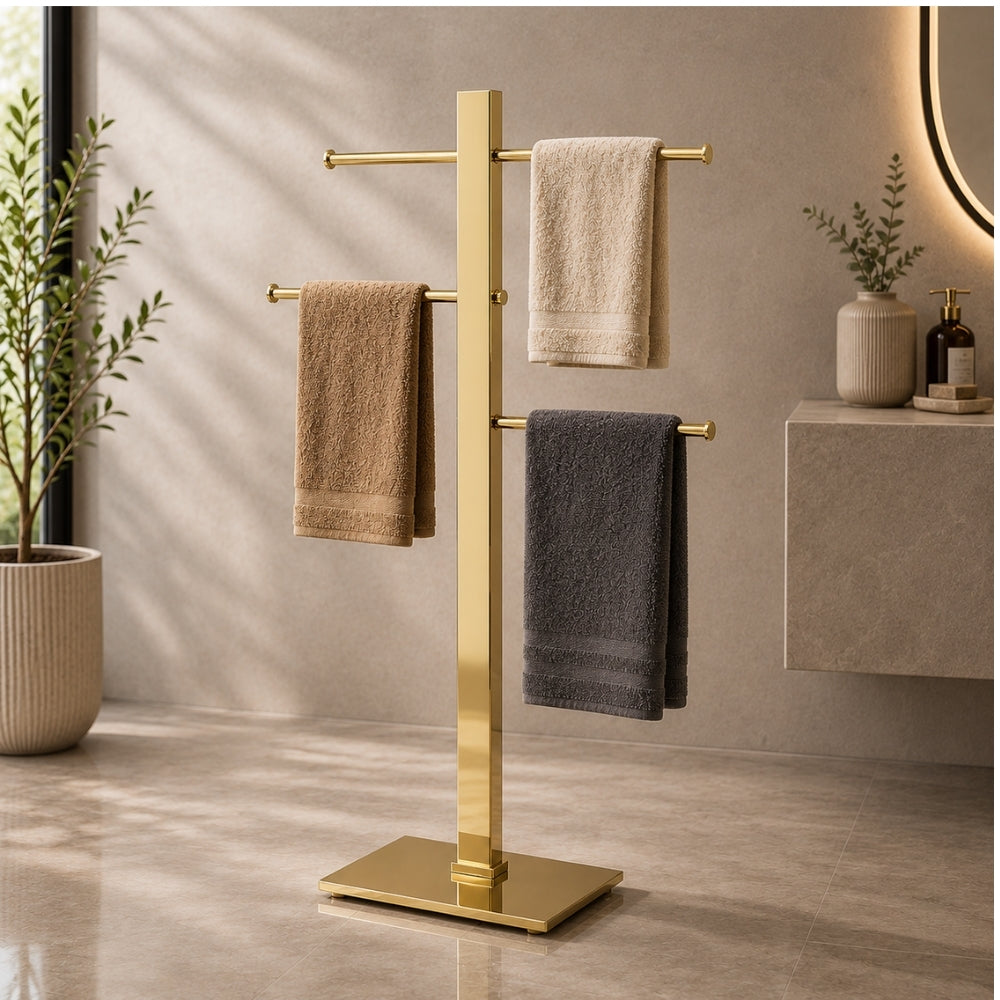 Gold freestanding 3-bar towel stand holding towels in a modern bathroom.
