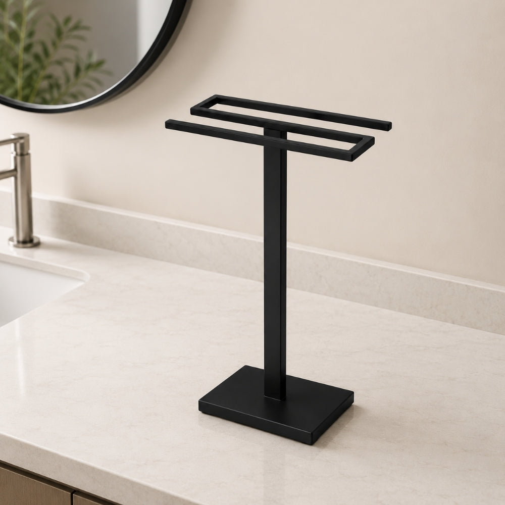 Black freestanding countertop double towel holder on a light bathroom vanity.