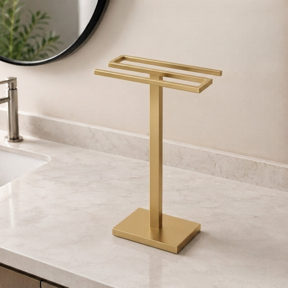Gold freestanding countertop double towel holder on a light bathroom vanity.