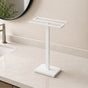 White freestanding countertop double towel holder on a light bathroom vanity.