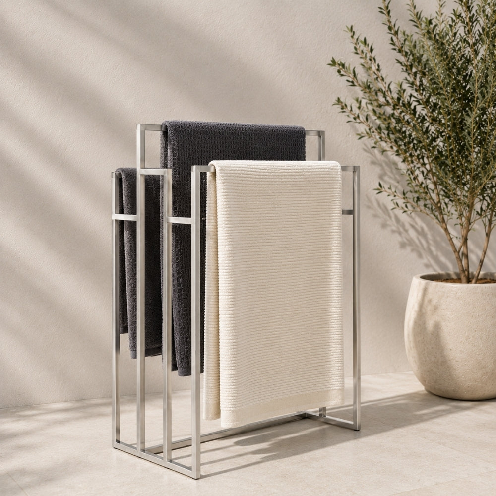 Satin nickel freestanding outdoor pool towel rack with multiple towels hanging on separate rails.