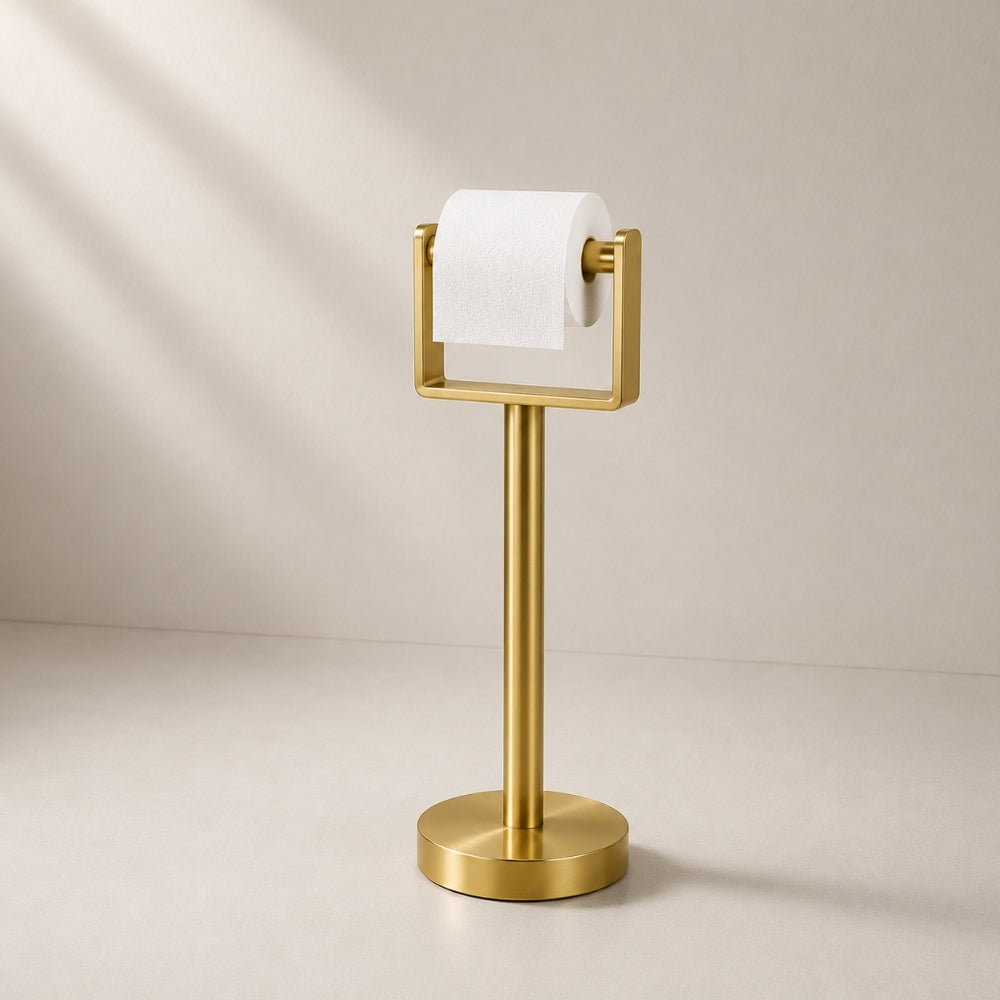 Gold freestanding toilet paper holder stand holding a toilet paper roll.