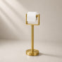 Gold freestanding toilet paper holder stand holding a toilet paper roll.