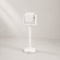 White freestanding toilet paper holder stand holding a toilet paper roll.