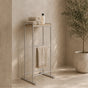 Satin nickel freestanding towel rack with top shelf holding folded towels and a hanging towel.