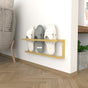A sleek wall-mounted slipper rack in gold, holding three pairs of slippers against a light wall, with wooden flooring and a nearby bookshelf adding warmth to the space.