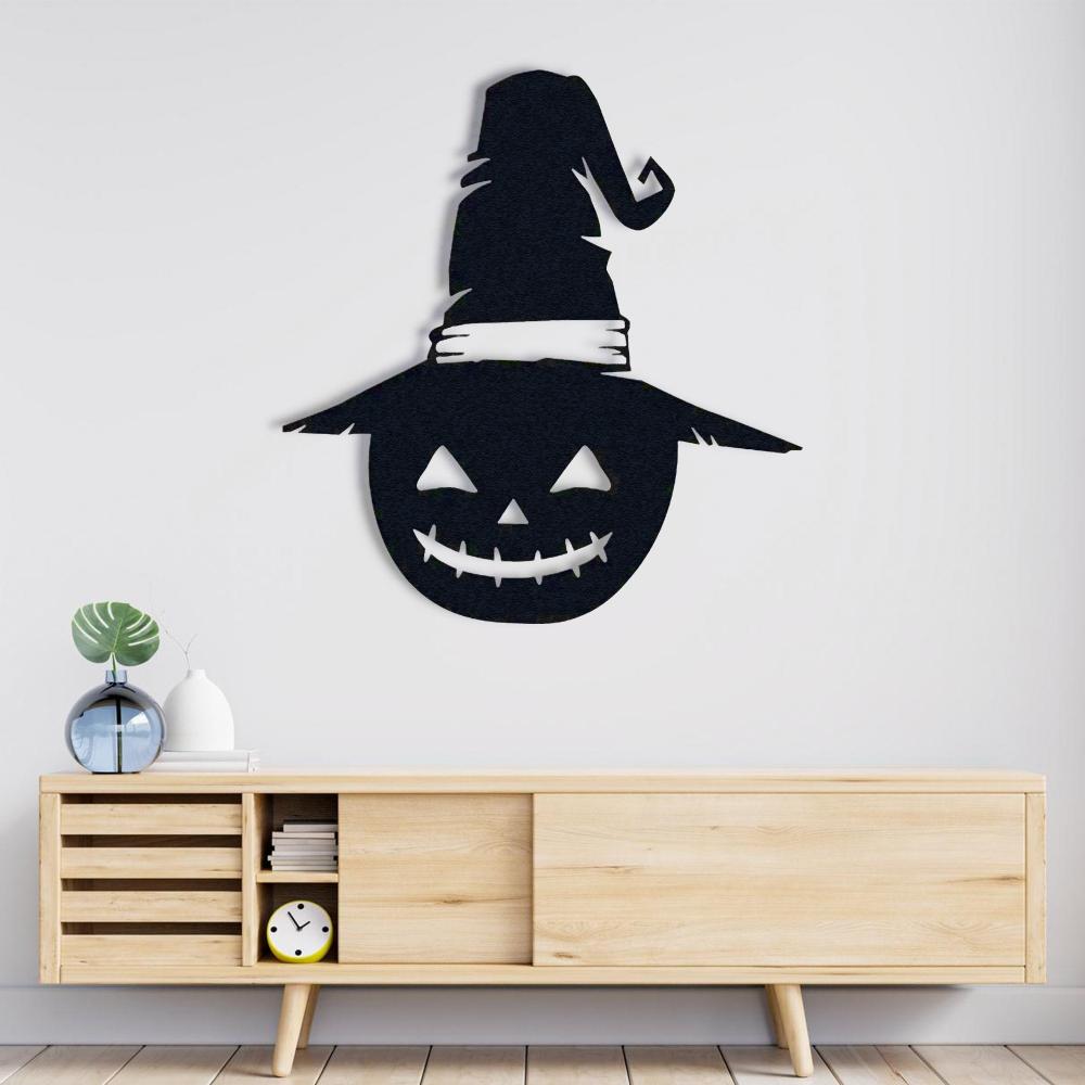 Minimalist black metal pumpkin wall decor with a witch's hat, displayed above a wooden console table in a modern living room. 