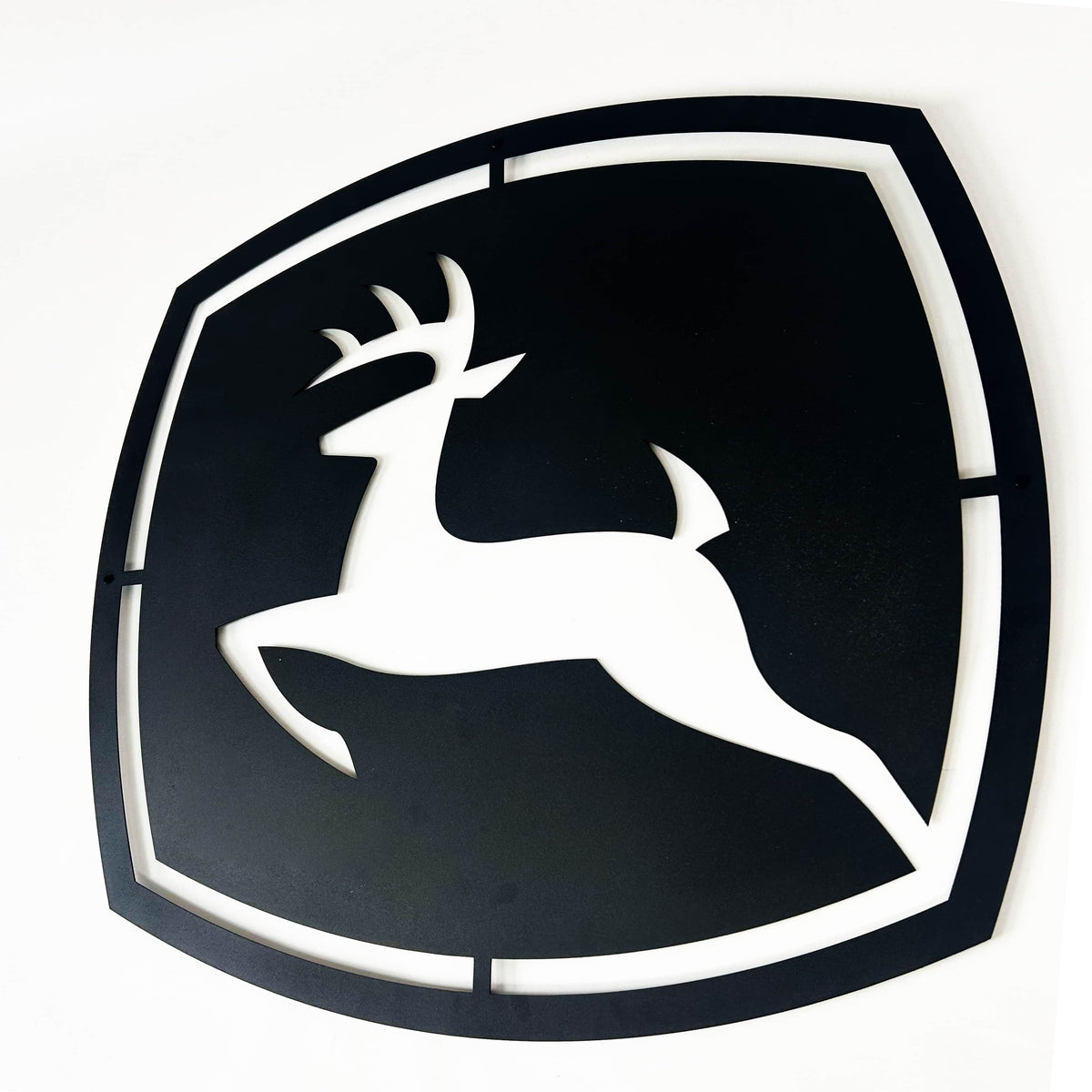John Deere Metal Wall Art, laser-cut deer emblem displayed on a wall in a modern interior setting.