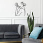 Abstract line art depicting a female figure with flowers, placed above a gray couch with blue and gray decorative cushions, styled in a contemporary room.