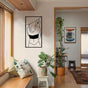 Stylish hallway decorated with potted plants and a modern metal wall art of a woman in a hat, adding elegance to the space.