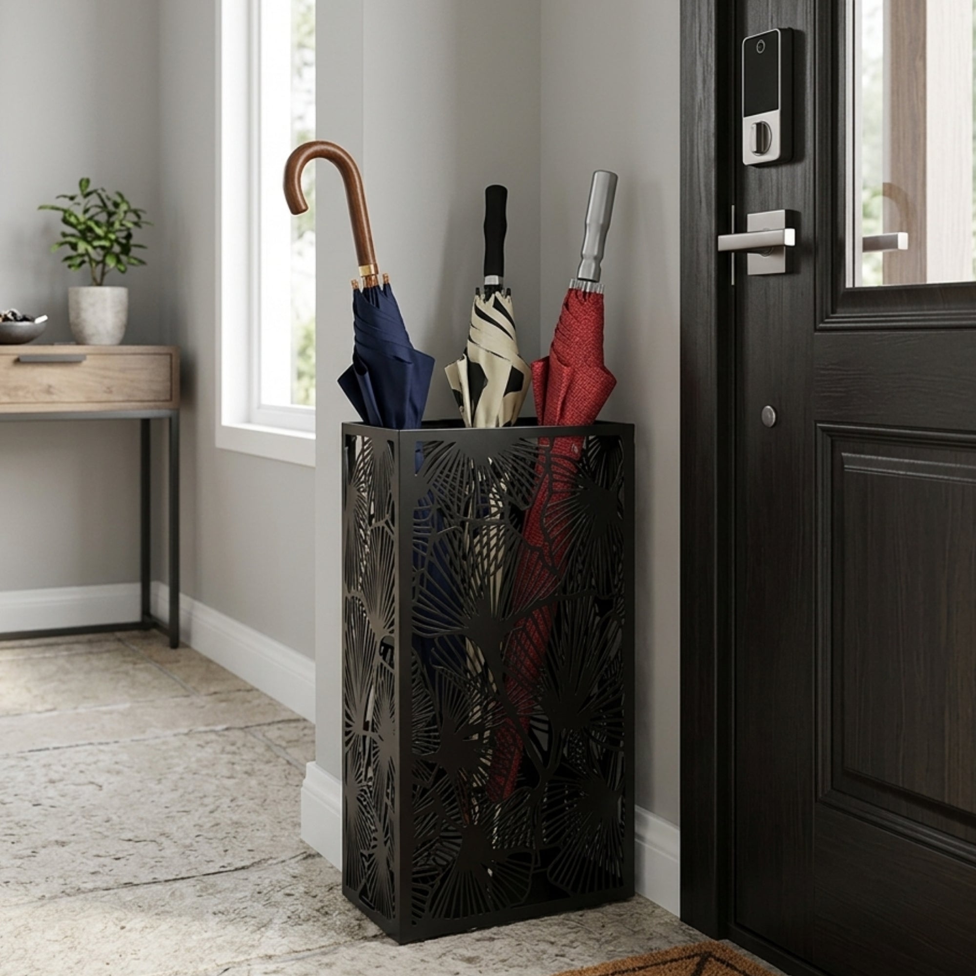 Black leaf pattern metal umbrella stand in modern entryway holding multiple umbrellas with handles