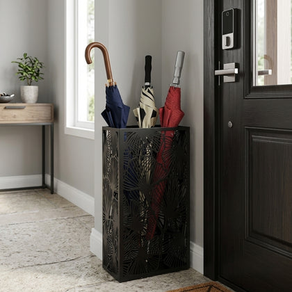 Black leaf pattern metal umbrella stand in modern entryway holding multiple umbrellas with handles