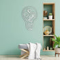 Minimalist room with a mint green wall featuring a white light bulb-shaped metal wall art design with gears, complemented by a wooden shelving unit showcasing decor items and a cozy bench draped with a white throw.