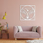 Elegant white metal wall art of a hummingbird with wings spread inside a geometric circular frame, mounted on a pastel pink wall above a modern pink sofa.