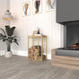 A minimalist metal log rack with a gold frame and wooden top, showcased in a warm interior with modern design elements