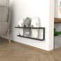 A minimalist black wall-mounted slipper rack on a plain background, holding three pairs of slippers, shown for small spaces with a focus on functionality and style.
