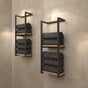 minimalistic black metal wall-mounted shelves with a light wood base, neatly holding dark gray towels against a beige wall