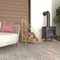 Gold Modern Triangle Metal Wood Rack with a modern triangular structure, displayed indoors near a wood stove, showcasing its luxurious and stylish design