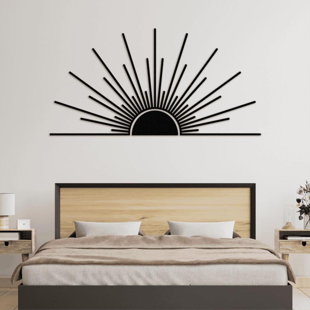 Modern sunburst metal wall art in black, mounted above a minimalist wooden bed with a neutral-toned comforter. The wall art features a sunrise design with radiating lines, perfect for adding a statement piece 