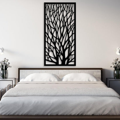Black metal tree wall art featuring intricate branching patterns mounted above a modern bed with a white headboard and neutral bedding. The bedside tables are decorated with vases of white flowers and modern lamps, creating a serene and elegant bedroom atmosphere.
