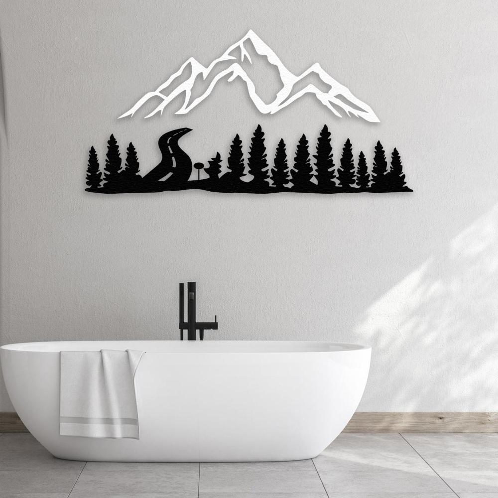 Black and white mountain and forest-themed metal wall decor mounted above a modern white freestanding bathtub, creating a serene and stylish bathroom ambiance with natural light accentuating the minimalist decor.